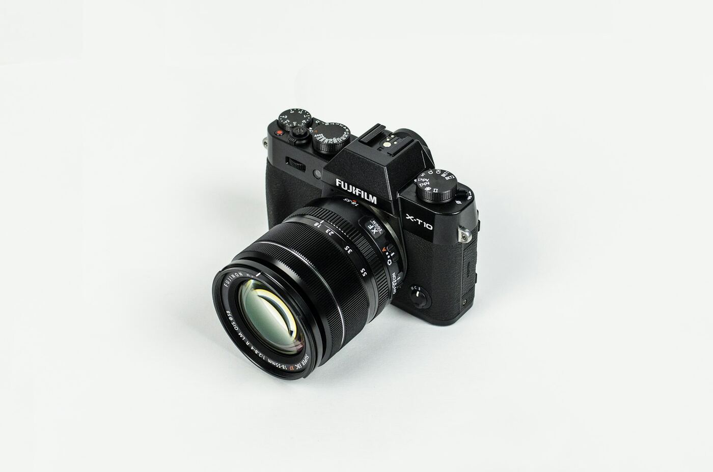 A black Fujifilm mirrorless camera on a white table